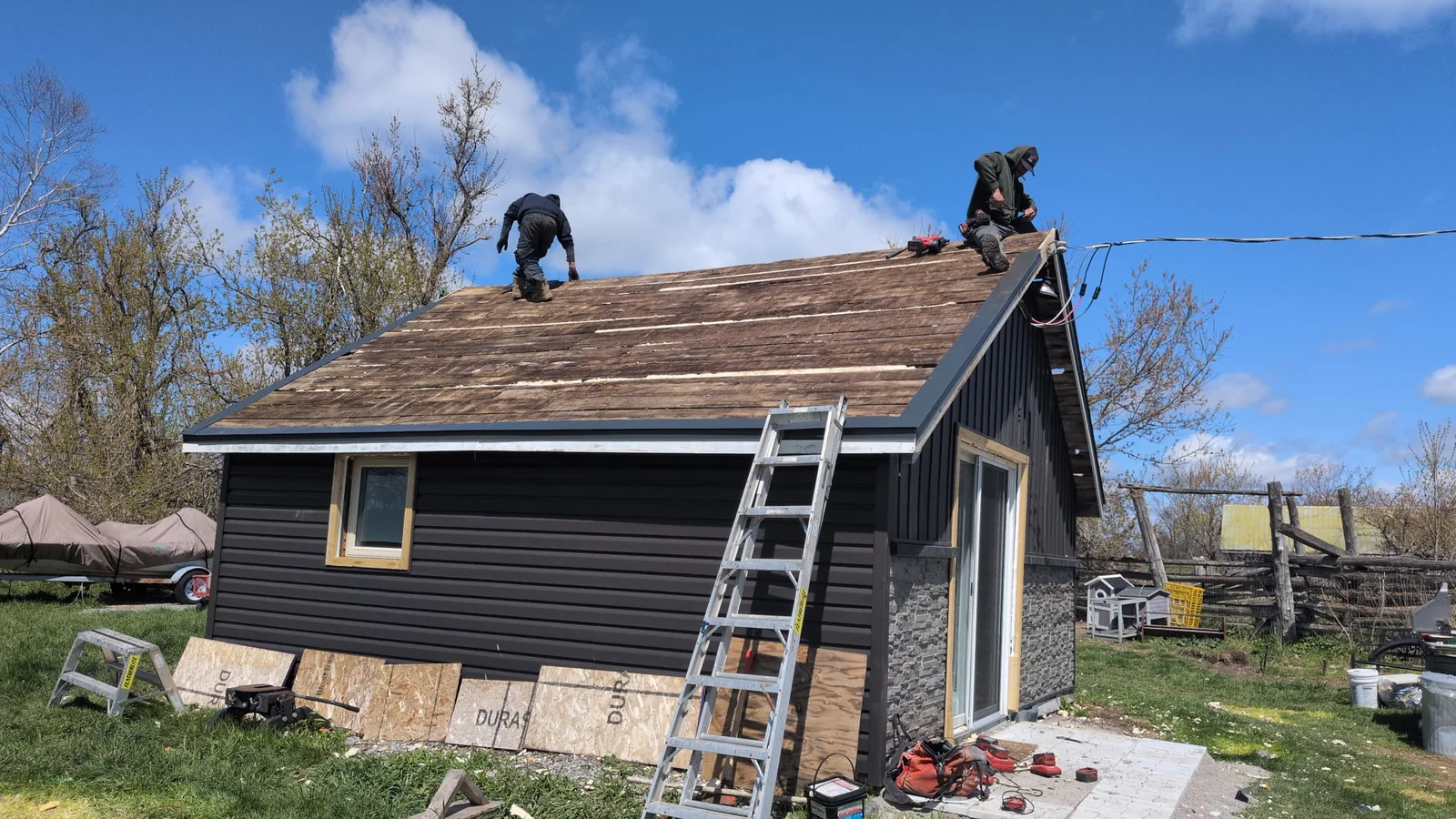 Gray house roof at tear-off stage before standing seam panels were installed.