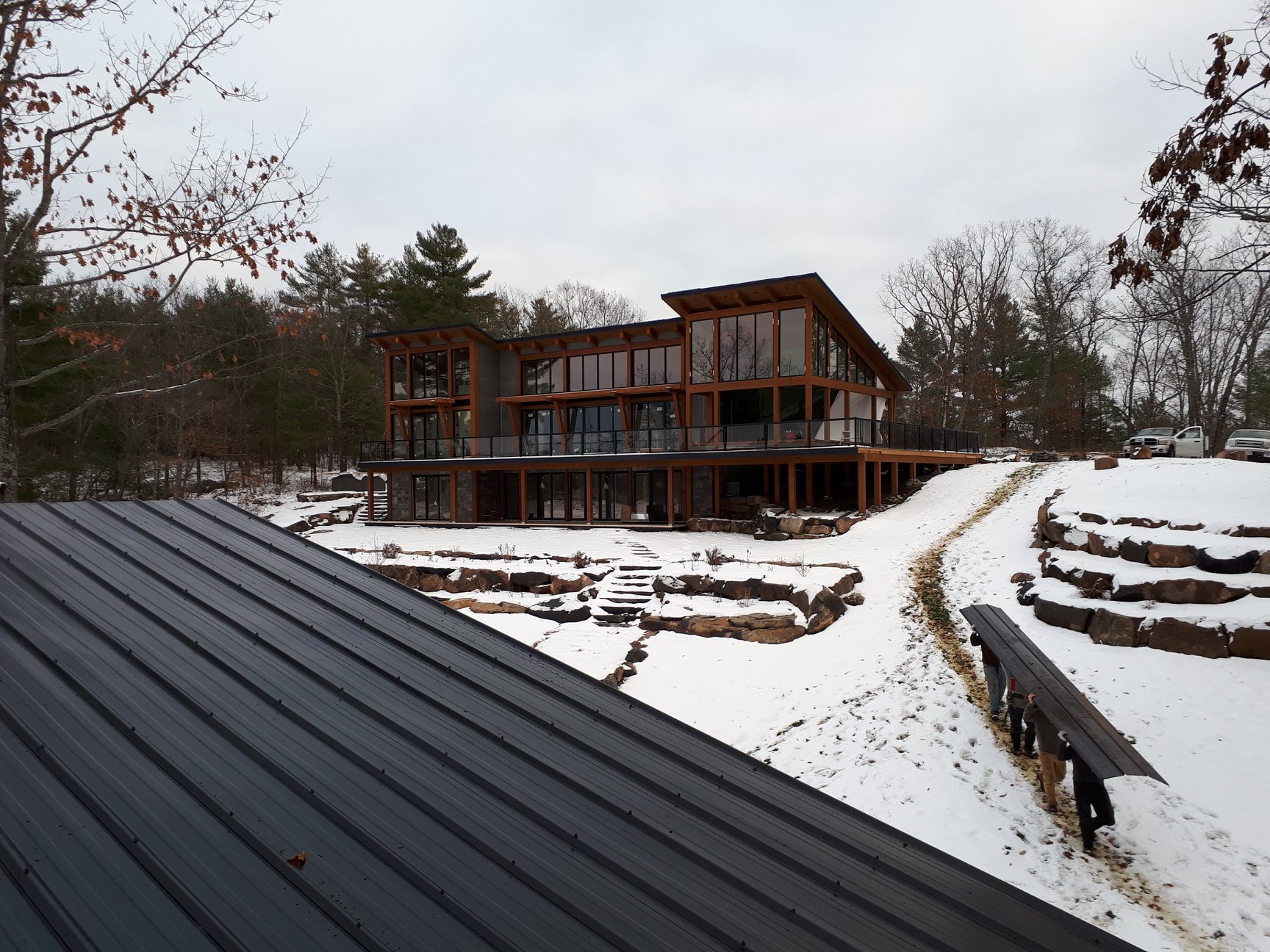 Standing seam roof in the foreground with a finished estate home beyond.